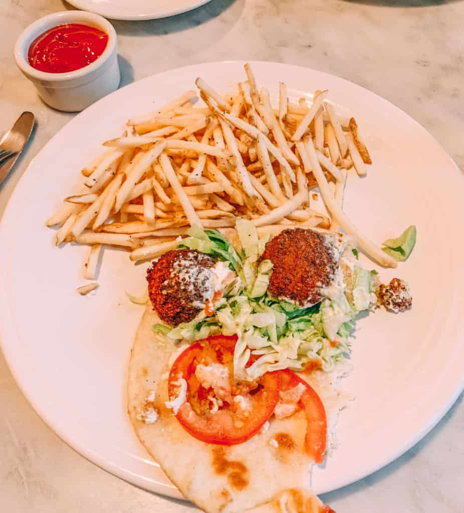 image of Mizuna falafel with tomato, greens, chevre, cucumber-chili drizzle and fries